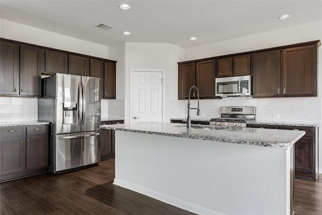 825 Fortrose Ter, Pflugerville, TX 78660 - kitchen with appliances with stainless steel finishes, dark brown cabinetry, light stone countertops, and recessed lighting