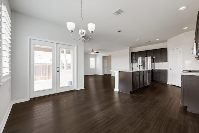 825 Fortrose Ter, Pflugerville, TX 78660 - kitchen with a chandelier, open floor plan, dark brown cabinets, french doors, and dark wood finished floors