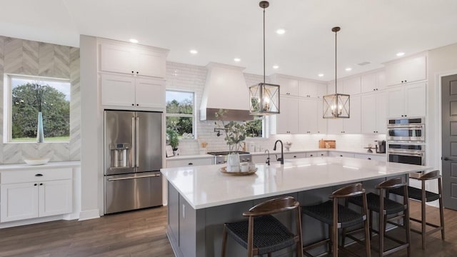 LOT13 Ridgeway Trl, Johnson City, TX 78636 - kitchen with appliances with stainless steel finishes, custom range hood, light countertops, white cabinets, and a breakfast bar area