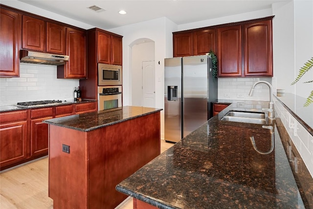 30 Stone Terrace Dr, Austin, TX 78734 - kitchen featuring stainless steel appliances, under cabinet range hood, a kitchen island, dark brown cabinets, and dark stone counters
