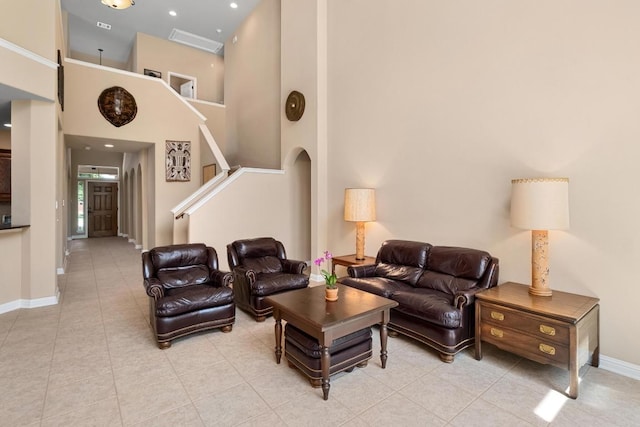 161 Serene Hollow Ln, Buda, TX 78610 - living area with light tile patterned floors, baseboards, a towering ceiling, and stairs