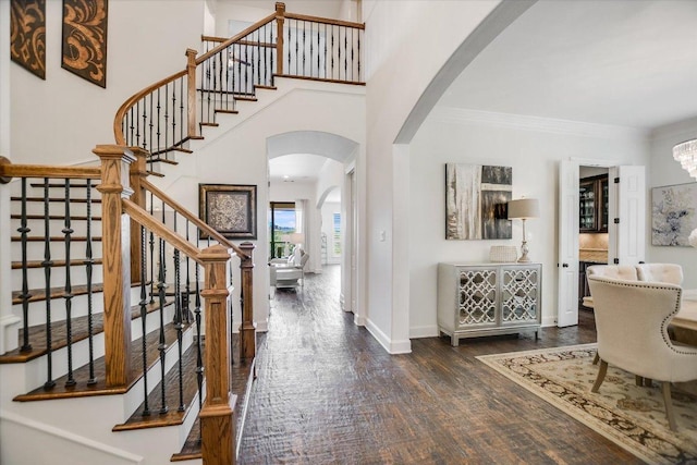 1016 Santaluz Path, Austin, TX 78732 - entrance foyer with arched walkways, stairway, dark wood-style floors, ornamental molding, and a chandelier