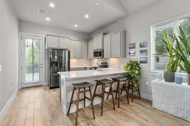 213 Virtus Bnd Unit 25, Austin, TX 78748 - kitchen featuring appliances with stainless steel finishes, a peninsula, light wood-style flooring, baseboards, and recessed lighting