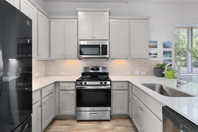 213 Virtus Bnd Unit 25, Austin, TX 78748 - kitchen featuring stainless steel appliances, a sink, light countertops, tasteful backsplash, and gray cabinets