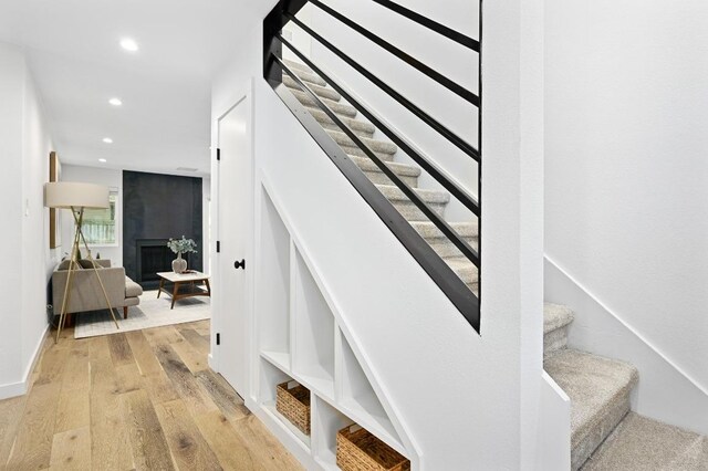 3415 Clarksburg Dr, Austin, TX 78745 - stairs featuring hardwood / wood-style floors, recessed lighting, a large fireplace, and baseboards