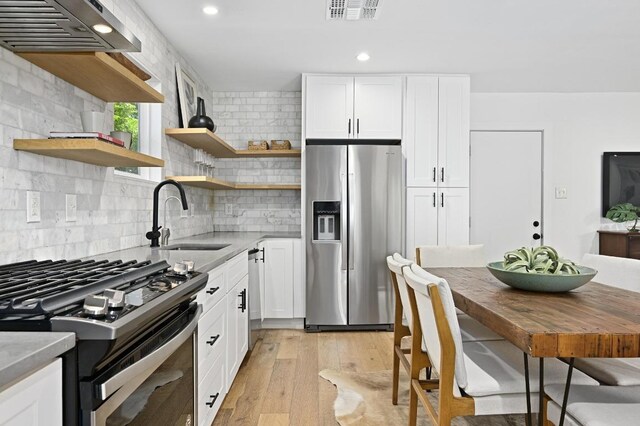 3415 Clarksburg Dr, Austin, TX 78745 - kitchen with appliances with stainless steel finishes, a sink, open shelves, recessed lighting, and decorative backsplash