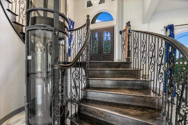 427 Bella Montagna Cir, Austin, TX 78734 - staircase with plenty of natural light, french doors, a towering ceiling, and baseboards