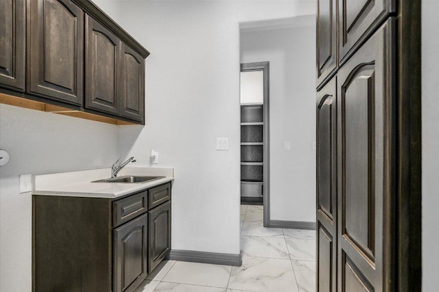427 Bella Montagna Cir, Austin, TX 78734 - laundry area featuring light marble finish floors, a sink, and baseboards