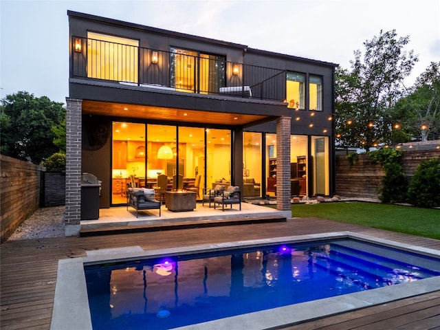 2024 Ford St, Austin, TX 78704 - back of property featuring a balcony, a fenced backyard, a deck, and an outdoor living space with a fire pit