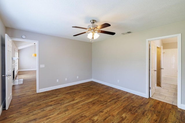 1307 Rambling Cv, Cedar Park, TX 78613 - unfurnished bedroom featuring wood finished floors, baseboards, ceiling fan, and ensuite bathroom
