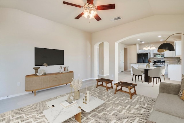 11117 Old Quarry Rd, Austin, TX 78717 - living room featuring arched walkways, lofted ceiling, ceiling fan, a chandelier, and baseboards