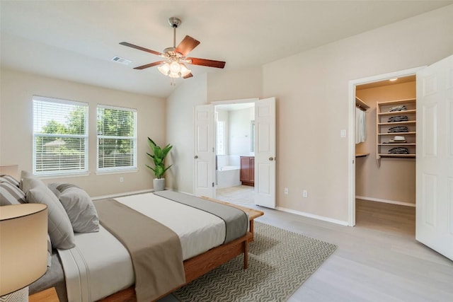 11117 Old Quarry Rd, Austin, TX 78717 - bedroom with a spacious closet, wood finished floors, baseboards, ensuite bathroom, and lofted ceiling