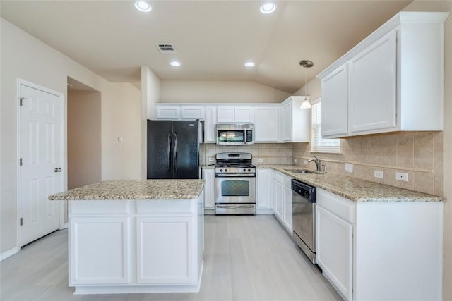 11117 Old Quarry Rd, Austin, TX 78717 - kitchen featuring appliances with stainless steel finishes, a sink, light wood-style floors, white cabinets, and lofted ceiling