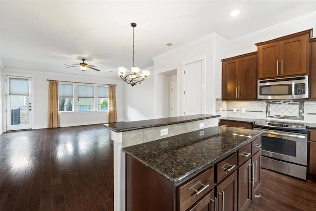 14501 Falcon Head Blvd Unit 43, Austin, TX 78738 - kitchen with appliances with stainless steel finishes, a kitchen island, backsplash, dark stone counters, and open floor plan