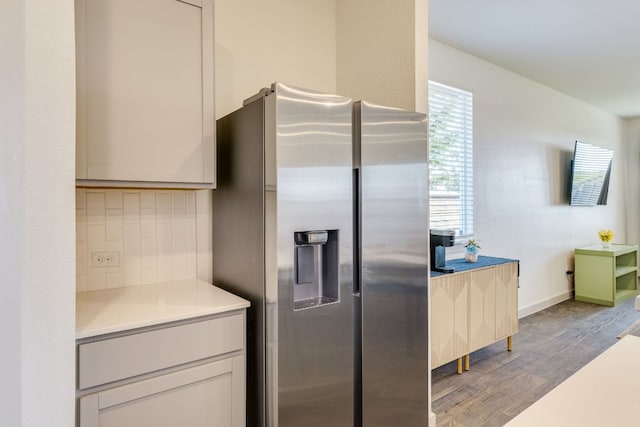 98 Barton Creek Ln, Hutto, TX 78634 - kitchen featuring stainless steel fridge with ice dispenser, wood finished floors, backsplash, and light countertops
