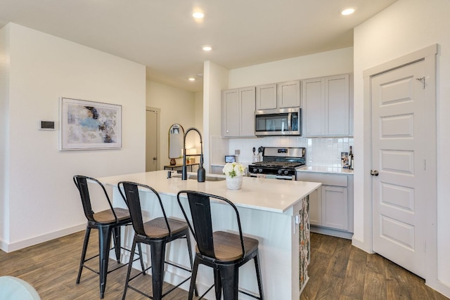98 Barton Creek Ln, Hutto, TX 78634 - kitchen with appliances with stainless steel finishes, gray cabinets, a sink, dark wood finished floors, and recessed lighting