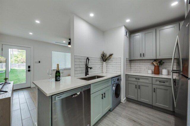 1200 E 52nd St Unit 105, Austin, TX 78723 - kitchen featuring appliances with stainless steel finishes, a sink, washer / clothes dryer, healthy amount of natural light, and recessed lighting