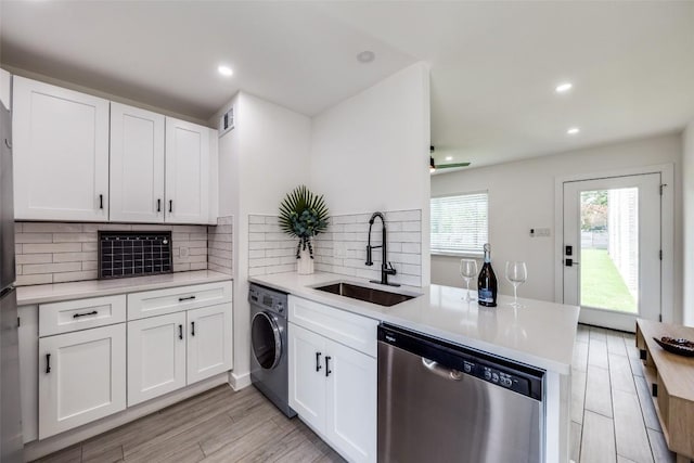 1200 E 52nd St Unit 105, Austin, TX 78723 - kitchen with stainless steel dishwasher, washer / clothes dryer, a peninsula, a sink, and light countertops