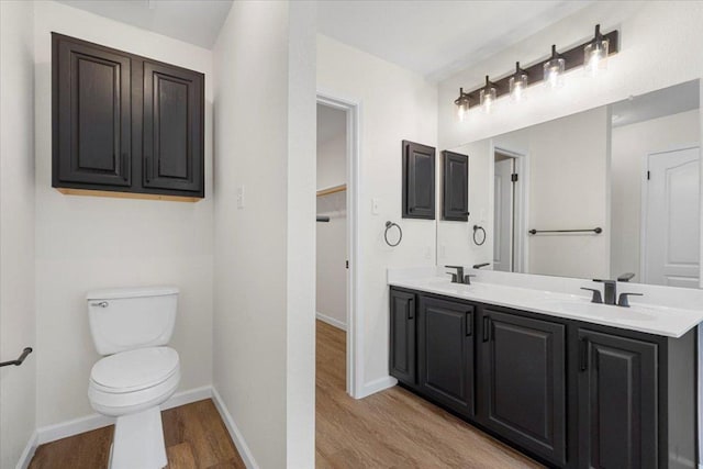 404 N Belinda Ct, Bastrop, TX 78602 - full bathroom featuring wood finished floors, toilet, double vanity, baseboards, and a closet