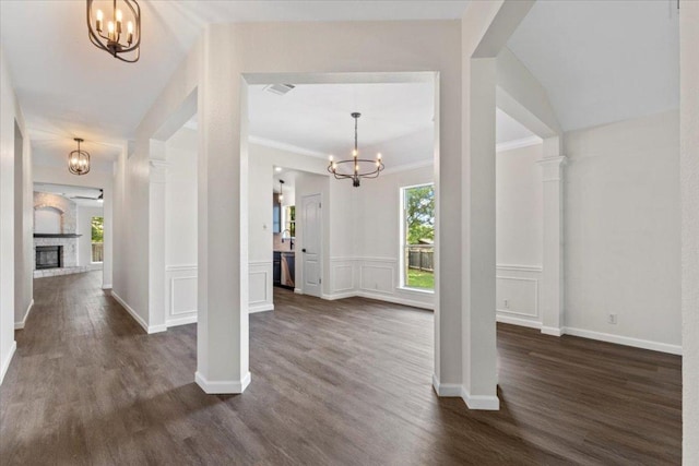 404 N Belinda Ct, Bastrop, TX 78602 - entrance foyer featuring a chandelier, dark wood-style flooring, a fireplace, crown molding, and baseboards