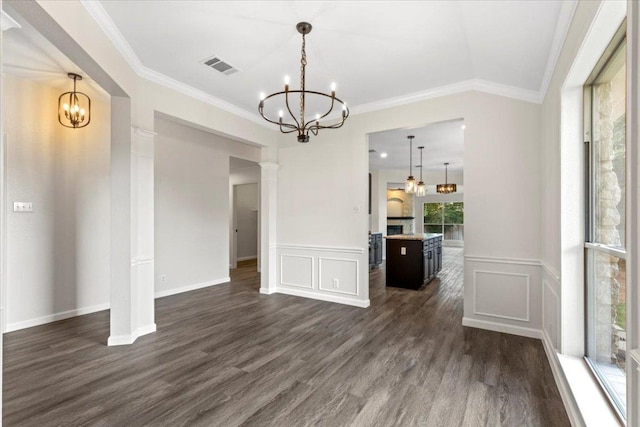 404 N Belinda Ct, Bastrop, TX 78602 - unfurnished dining area featuring a chandelier, dark wood-style flooring, ornamental molding, a decorative wall, and wainscoting
