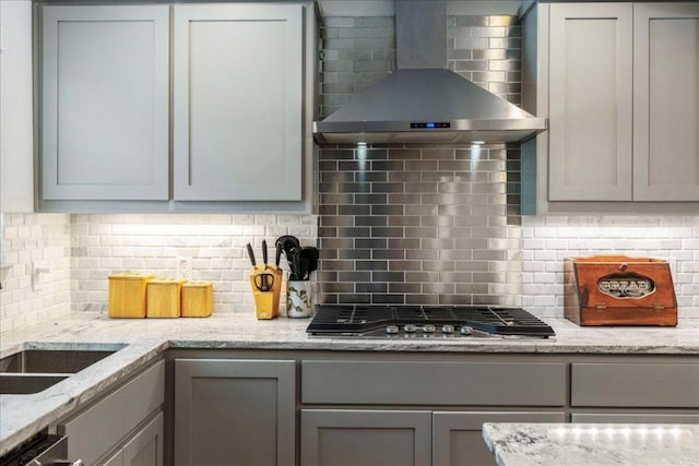 5701 Ave G, Austin, TX 78752 - kitchen with wall chimney exhaust hood, backsplash, and gray cabinetry