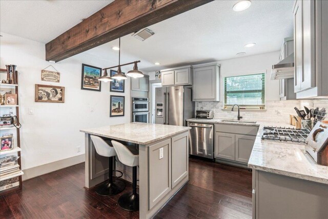 5701 Ave G, Austin, TX 78752 - kitchen featuring stainless steel appliances, gray cabinetry, light stone countertops, beamed ceiling, and recessed lighting