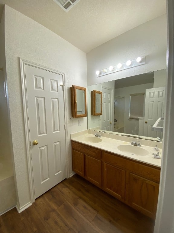 1119 Burgess Dr, Leander, TX 78641 - bathroom featuring wood finished floors, double vanity, and a shower