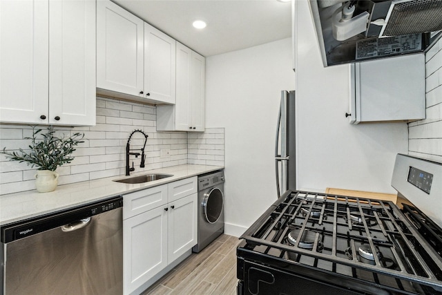 1200 E 52nd St Unit 101, Austin, TX 78723 - kitchen featuring stainless steel appliances, washer / dryer, white cabinetry, range hood, and recessed lighting