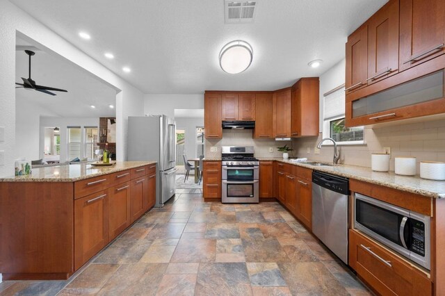 2405 Monarch Dr, Austin, TX 78748 - kitchen with stainless steel appliances, a sink, tasteful backsplash, a ceiling fan, and light stone countertops