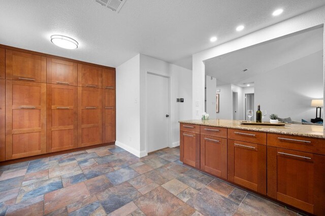 2405 Monarch Dr, Austin, TX 78748 - bathroom featuring stone tile floors, baseboards, recessed lighting, and vanity