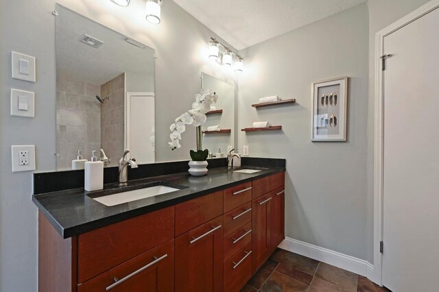 2405 Monarch Dr, Austin, TX 78748 - full bath with double vanity, baseboards, and a tile shower