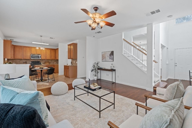 14404 Showdown Ln, Austin, TX 78717 - living room with stairs, wood finished floors, a ceiling fan, and baseboards