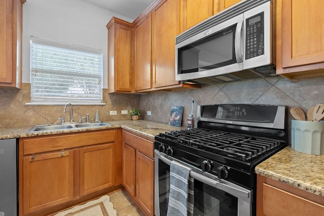 14404 Showdown Ln, Austin, TX 78717 - kitchen featuring appliances with stainless steel finishes, a sink, tasteful backsplash, brown cabinetry, and light stone countertops