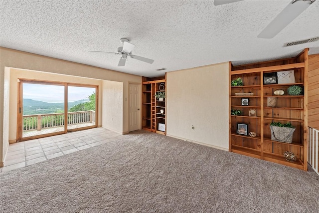 11105 Highview Dr, Belton, TX 76513 - unfurnished living room with ceiling fan, a textured ceiling, tile patterned flooring, and carpet