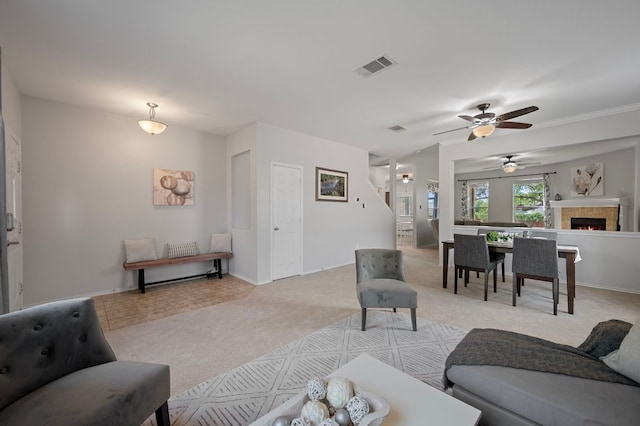 145 Trinity Dr, Kyle, TX 78640 - living room featuring light colored carpet, ceiling fan, a warm lit fireplace, and baseboards