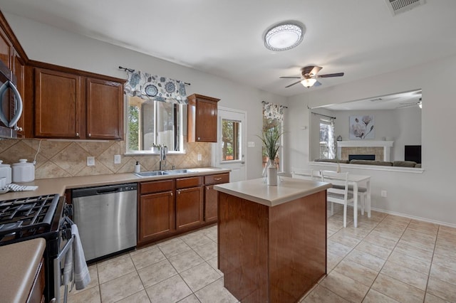145 Trinity Dr, Kyle, TX 78640 - kitchen with appliances with stainless steel finishes, ceiling fan, decorative backsplash, a sink, and light countertops