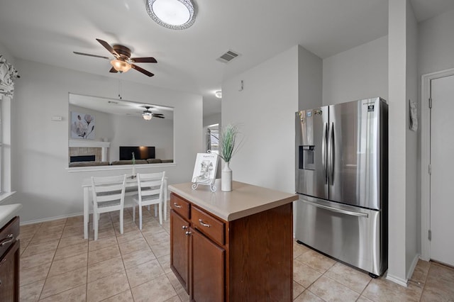 145 Trinity Dr, Kyle, TX 78640 - kitchen with stainless steel fridge with ice dispenser, a ceiling fan, light countertops, light tile patterned floors, and open floor plan