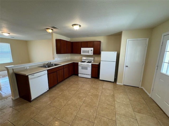12000 Briarcreek Loop, Manor, TX 78653 - kitchen with white appliances, a sink, light countertops, a peninsula, and light tile patterned floors