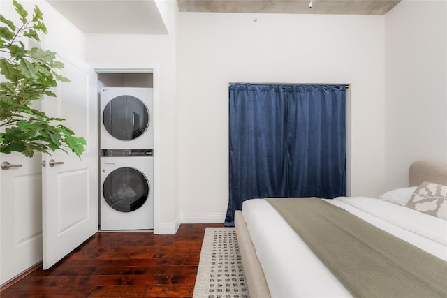 360 Nueces St Unit 1503, Austin, TX 78701 - bedroom featuring stacked washing machine and dryer, dark wood-type flooring, and baseboards