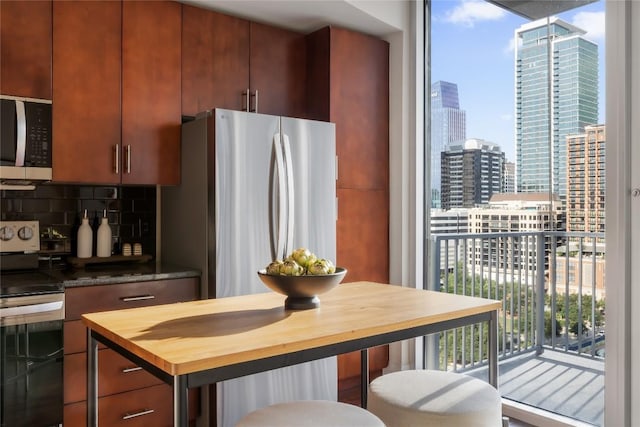 360 Nueces St Unit 1503, Austin, TX 78701 - kitchen with butcher block countertops, appliances with stainless steel finishes, backsplash, a city view, and a wall of windows