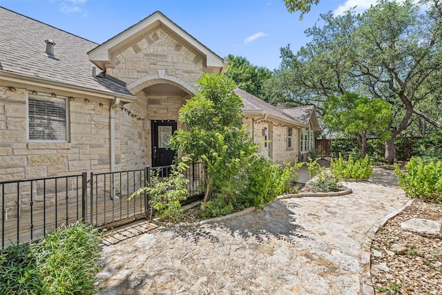 16 Troon Dr, Lakeway, TX 78738 - entrance to property with stone siding, a shingled roof, and a patio area