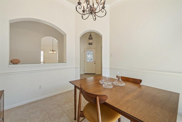 16 Troon Dr, Lakeway, TX 78738 - dining space featuring a chandelier, arched walkways, light tile patterned floors, a high ceiling, and baseboards