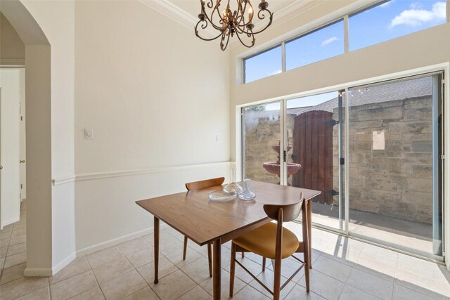16 Troon Dr, Lakeway, TX 78738 - tiled dining space with arched walkways, a chandelier, baseboards, and ornamental molding