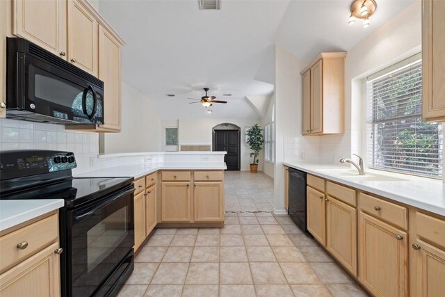 16 Troon Dr, Lakeway, TX 78738 - kitchen with black appliances, light brown cabinets, a peninsula, tasteful backsplash, and vaulted ceiling