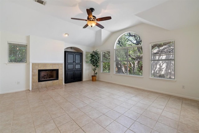 16 Troon Dr, Lakeway, TX 78738 - unfurnished living room featuring a ceiling fan, a tiled fireplace, lofted ceiling, tile patterned floors, and baseboards