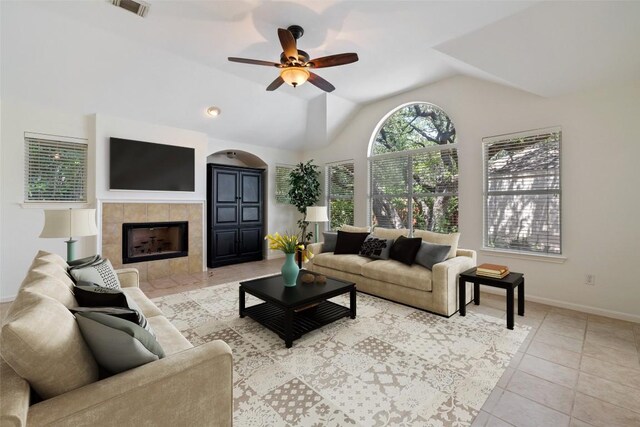 16 Troon Dr, Lakeway, TX 78738 - tiled living room featuring ceiling fan, vaulted ceiling, baseboards, and a tiled fireplace