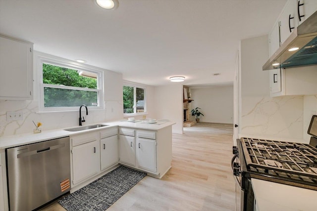 8011 Scotland Yard, Austin, TX 78759 - kitchen featuring appliances with stainless steel finishes, under cabinet range hood, light countertops, a peninsula, and recessed lighting