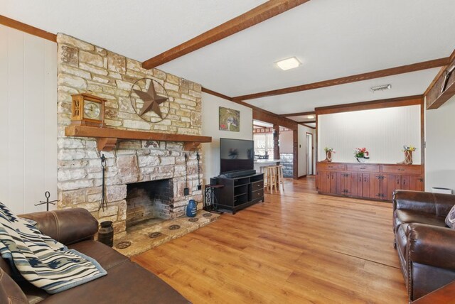701 W Steele St, Smiley, TX 78159 - living area with beam ceiling, light wood-style flooring, a fireplace, and a baseboard radiator