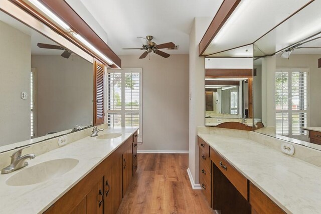 701 W Steele St, Smiley, TX 78159 - bathroom featuring ceiling fan, wood finished floors, baseboards, and double vanity